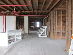 Front to back of the first floor of the future Community Center is shown here, ready for new construction. All pipes will be removed, and in front will be a large multi-purpose room. The back will house a kitchen, office, two bathrooms, and a study/computer room.