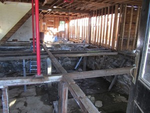 The view through the front door, looking down into the basement, shows the length of the building, even the old staircase is gone. Pouring cement and rebuilding the floor comes next.