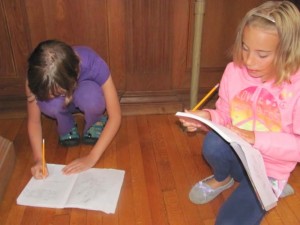Emma Carpenter edits a piece of writing with another camper last summer.