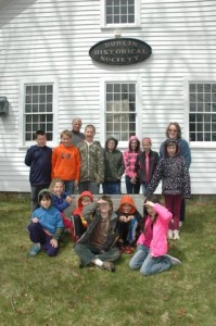The young students who visited the museum are (standing L-R): Riley Morse, Elias Niemela, Gareth Armstrong, Steven Van Etten, Alexis White, Morgan Wallace, Katelynn Horn and Deborah Bennett. Sitting in front of them are (L-R): Charlie Hall, Daisy Ober, Caleb Cloutier, Nick Parker, Carter Rousseau and Lilly Colon. Photo by Sally Shonk