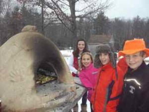 DCS fifth graders roasting our own garden potatoes in our new outdoor bread oven.