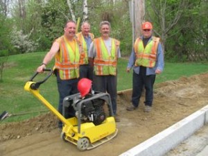 Our road crew (l-r: David Stone, Brian Barden, Mike Howe, and Roger Trempe) were hard at work completing the town sidewalk project along Route 101 (Main Street) in mid-May, the fifth or sixth year of the endeavor. Curbsides are in and the foundation is being readied. This just about wraps up the project. Photo by M. Gurney