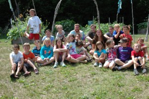 Children attending this year’s Playground gather with Eliot and counselors in front of the vegetable garden planted by students at DCS last spring in coordination with the Cornucopia Project. Photograph by Sally Shonk