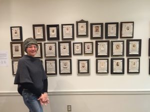 Jane Simpson stands in front of an installation of her new work in her frame studio on Grove Street in Peterborough. In these pieces, she combined vintage photographs of anonymous women with quotes from other renowned women – giving “voice” to women whose identities had been lost.